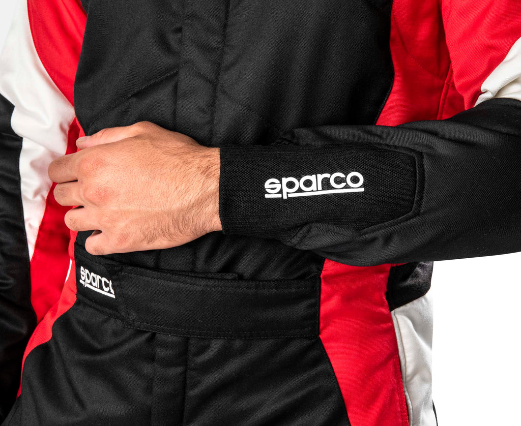 Sparco racing suit sleeve close-up with sparco logo cuff and red trim panels.