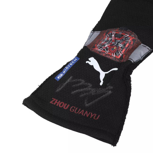 Black race glove with red patterned cuff patch and 'Zhou Guanyu' logo