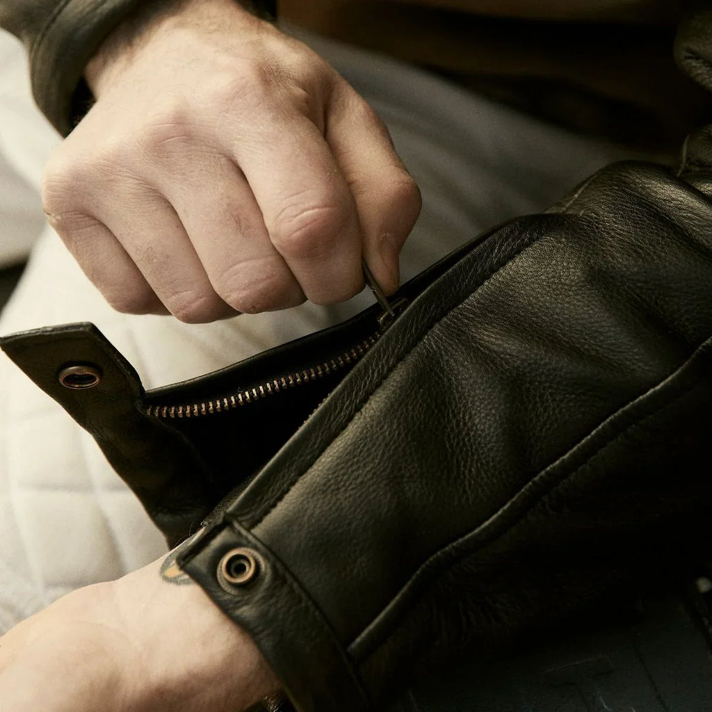 Close-up of a black leather jacket sleeve with zip and snap cuff