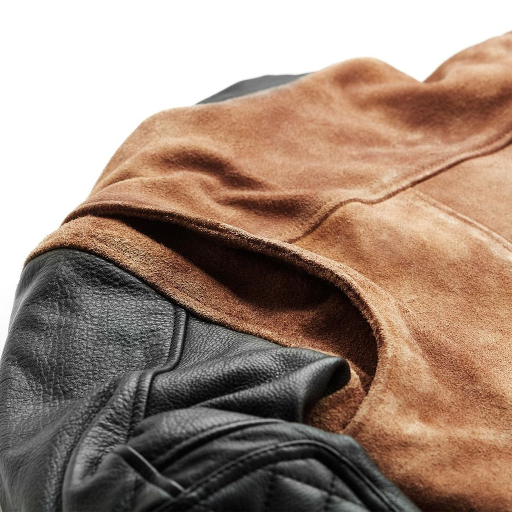 Close-up of the tan suede body and black leather sleeve seam