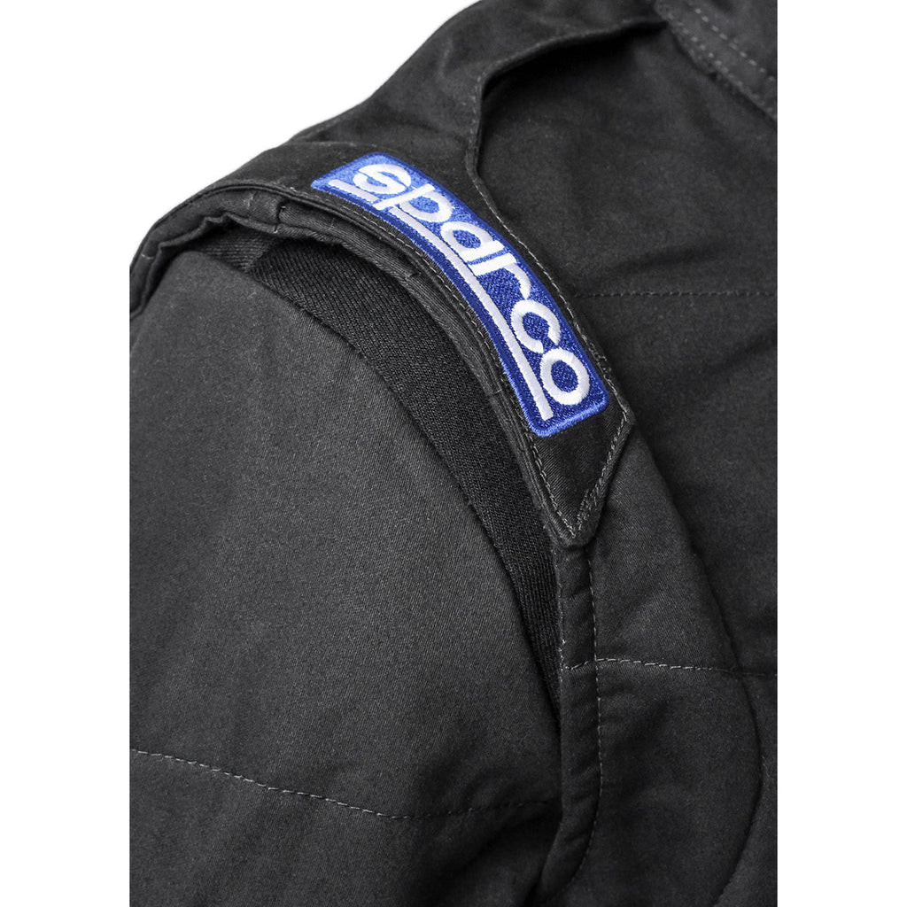 Black racing suit sleeve logo patch with blue stripe and stitched fabric panels
