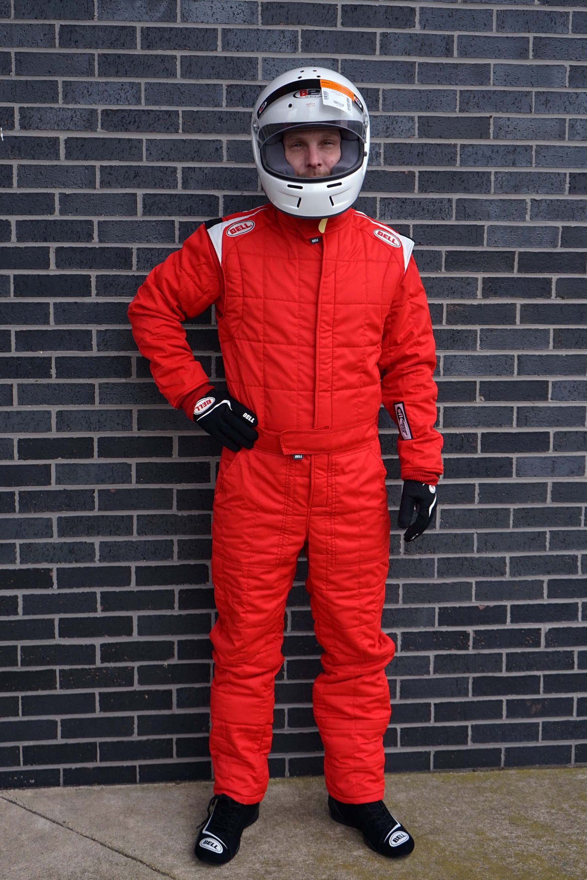 Red racing suit with white helmet, black gloves and boots